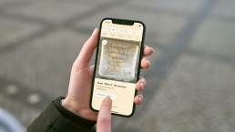Blick auf ein Smartphone, auf dem die App von Stolpersteine NRW geöffnet ist