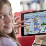 Mädchen hält Tablet mit Programmieren mit der Maus in der Hand