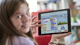 Mädchen hält Tablet mit Programmieren mit der Maus in der Hand